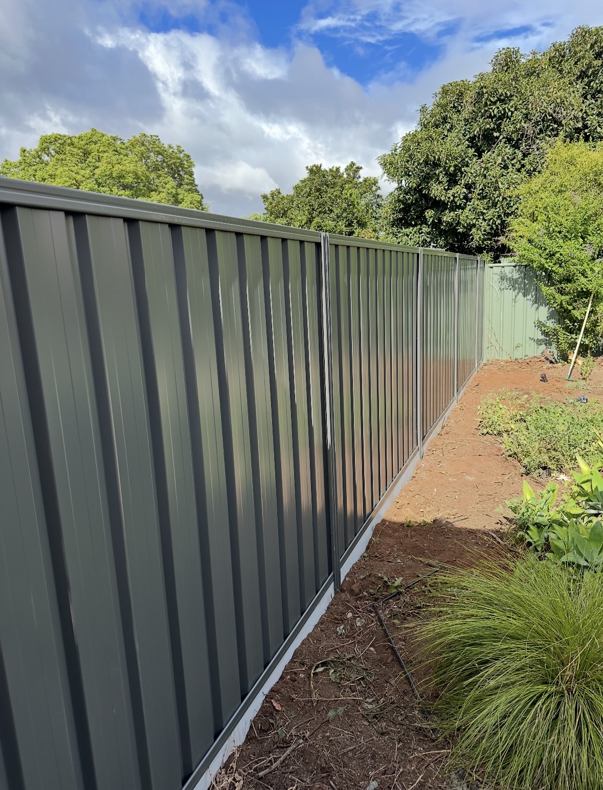 Repaired grey Colorbond boundary fence in an Adelaide suburb